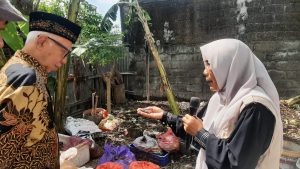 Ketua MUI Bali KH Mahrusun Hadiyono saat mengamati hasil maggot dari sampah organik di Rumah Imut Kepaon Denpasar (Dok. Infokom MUI Bali)